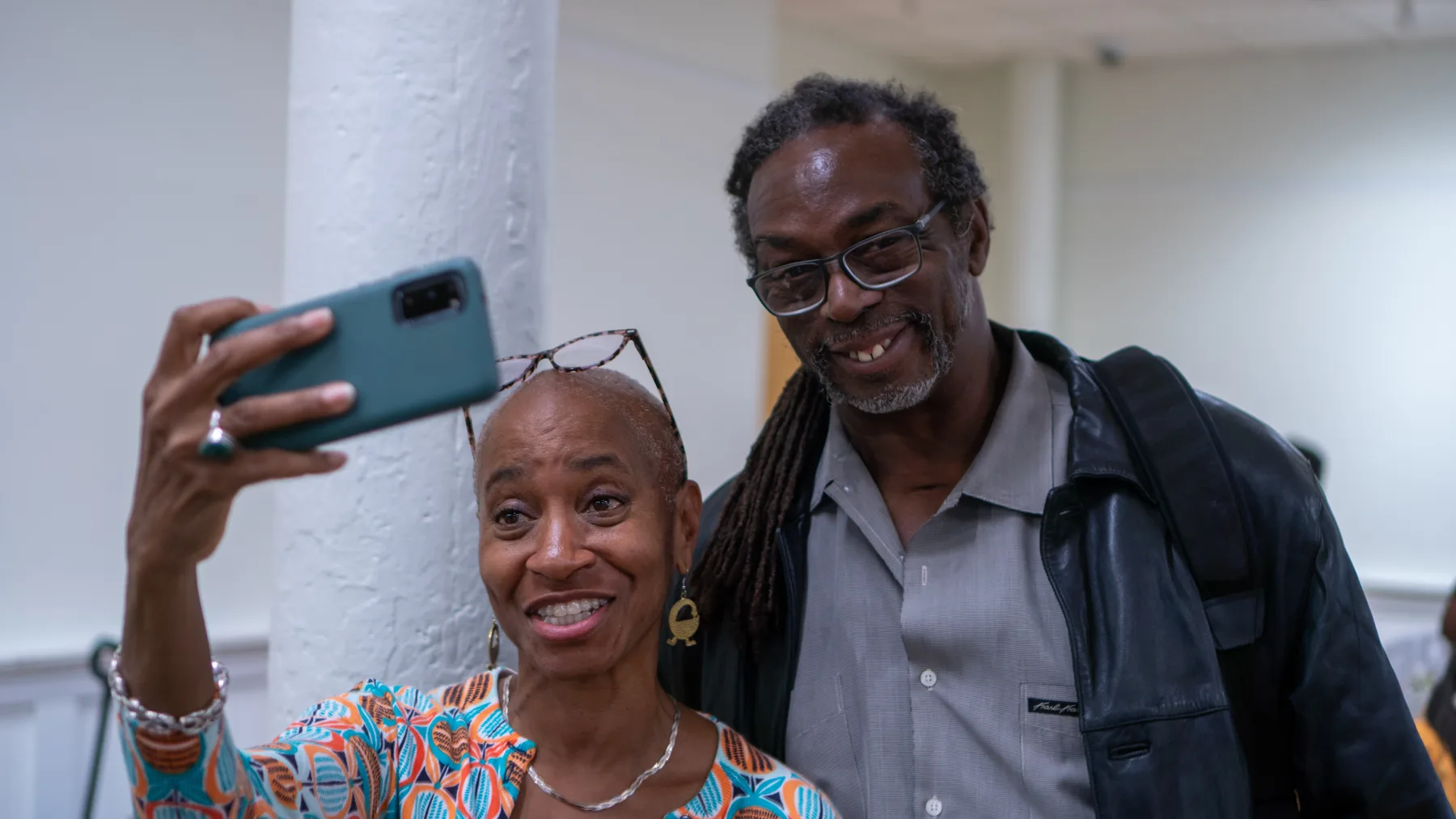 People look together at a phone or document.