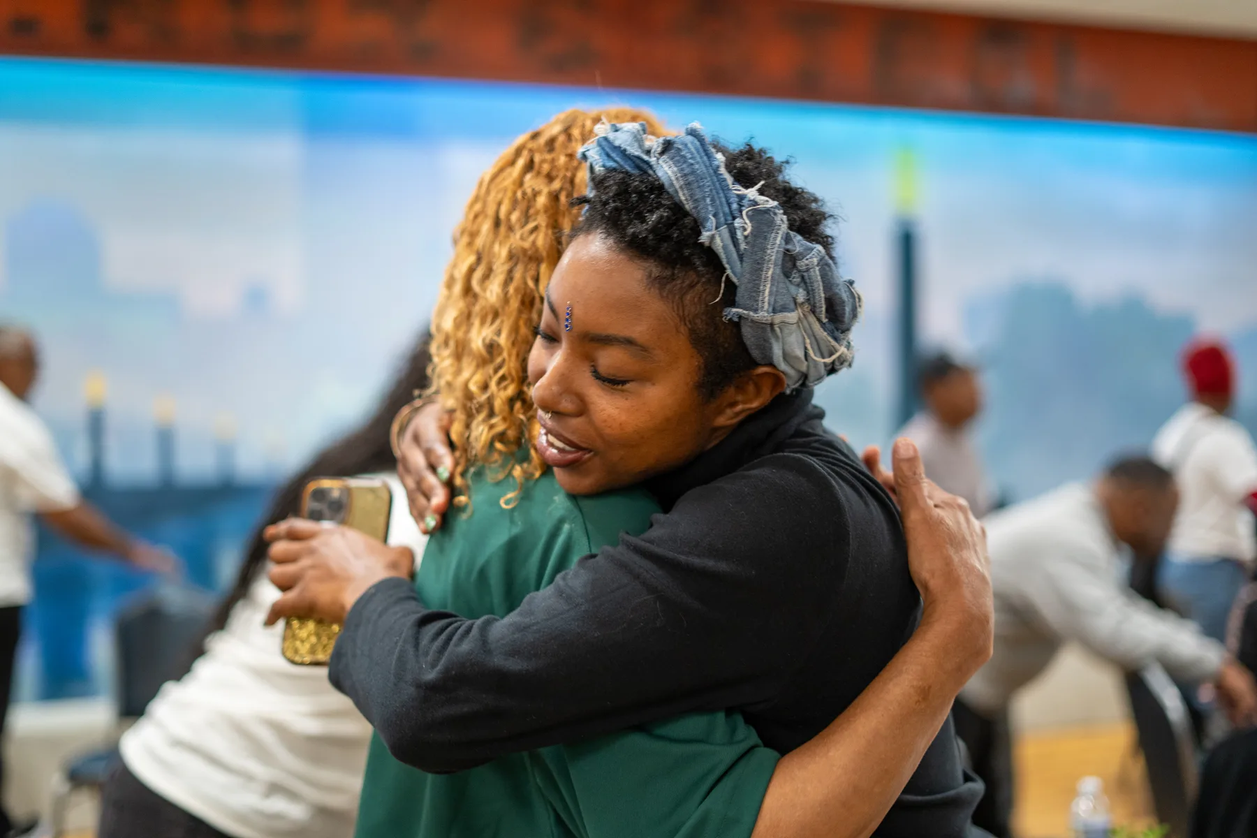 Two people embrace at a community gathering.