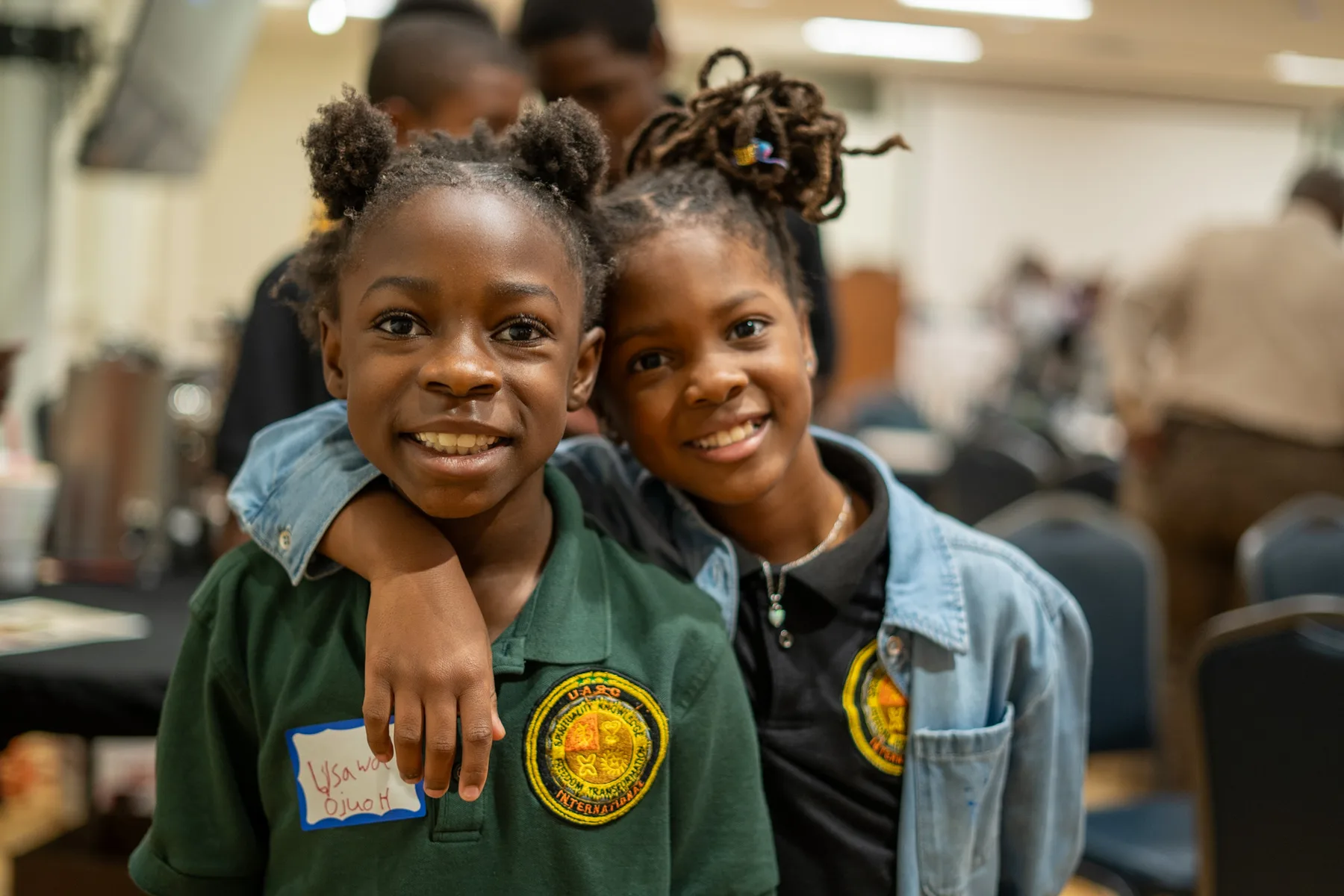 Two children smile at a community gathering.