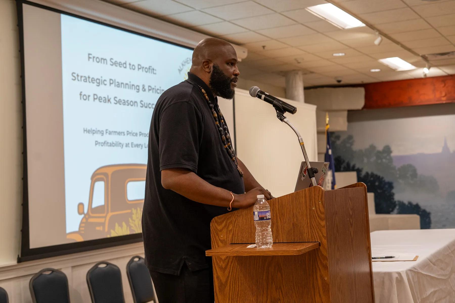 A speaker addresses an audience from a podium.